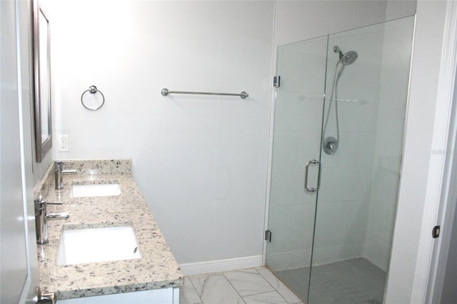 bathroom featuring double vanity, a shower stall, and a sink