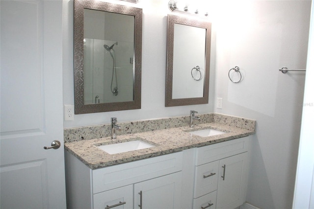 full bath featuring a shower stall, double vanity, and a sink