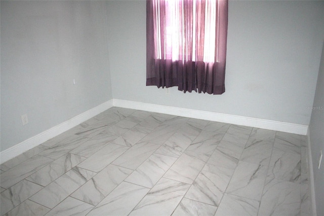 empty room with marble finish floor and baseboards