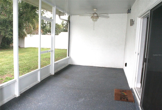 unfurnished sunroom featuring ceiling fan