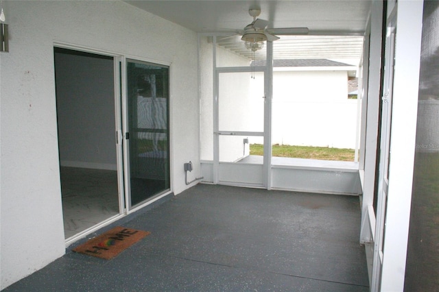 unfurnished sunroom featuring a ceiling fan