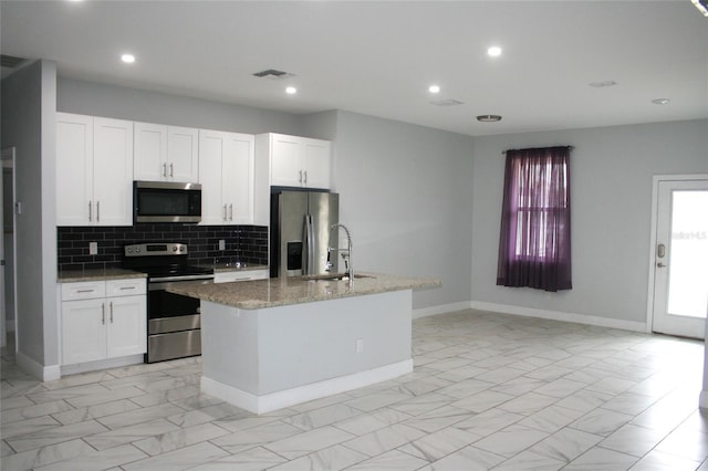 kitchen with a kitchen island with sink, white cabinets, and appliances with stainless steel finishes