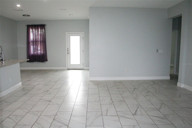 unfurnished room with recessed lighting, marble finish floor, and baseboards