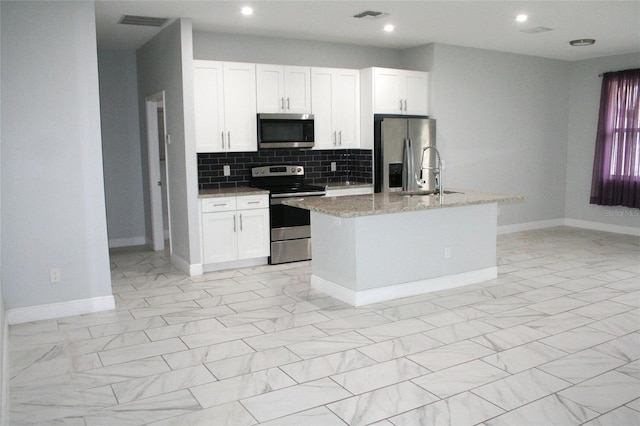 kitchen with a sink, light stone counters, marble finish floor, and stainless steel appliances