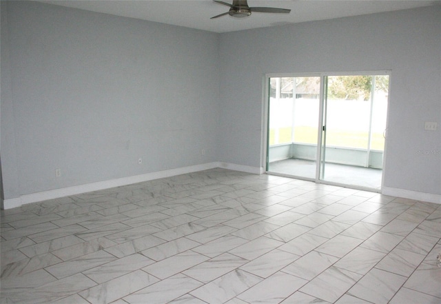 unfurnished room with marble finish floor, baseboards, and a ceiling fan