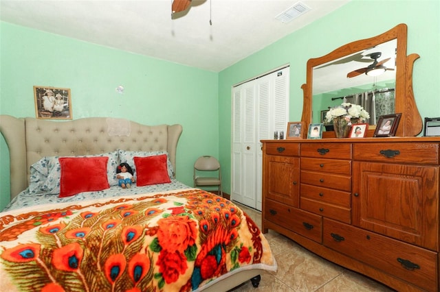 bedroom featuring light tile patterned floors, ceiling fan, and a closet