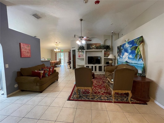 living room with a textured ceiling, tile patterned flooring, ceiling fan with notable chandelier, visible vents, and baseboards