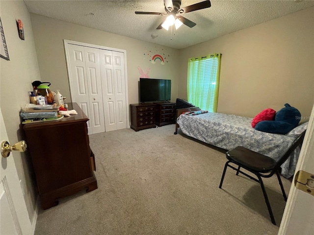 carpeted bedroom featuring a textured ceiling, ceiling fan, and a closet