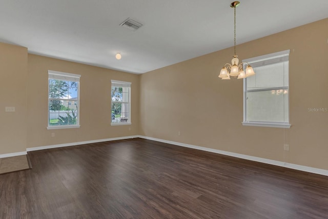 unfurnished room featuring a notable chandelier and dark hardwood / wood-style floors