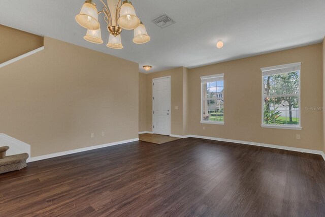 unfurnished room with dark hardwood / wood-style flooring and an inviting chandelier