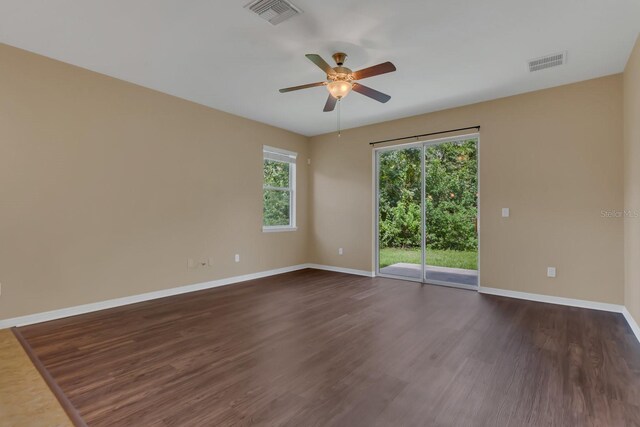 unfurnished room with plenty of natural light, ceiling fan, and dark hardwood / wood-style flooring