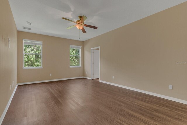 empty room featuring dark wood-type flooring and ceiling fan