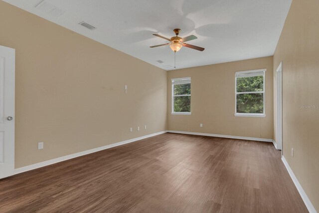 empty room with visible vents, baseboards, wood finished floors, and a ceiling fan