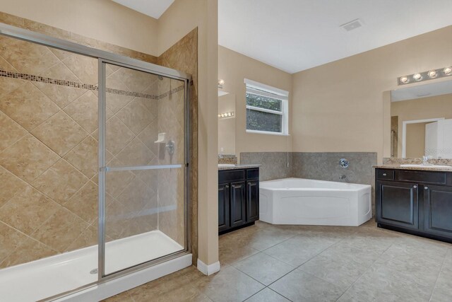 bathroom with vanity, plus walk in shower, and tile patterned flooring