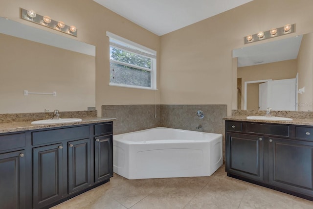 bathroom featuring vanity, tile patterned flooring, and a bathtub