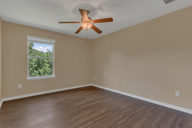 empty room with visible vents, baseboards, a ceiling fan, and dark wood-style flooring