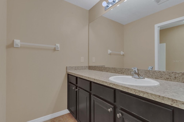 bathroom with baseboards, vanity, and tile patterned flooring