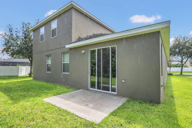 rear view of property with a lawn and a patio area