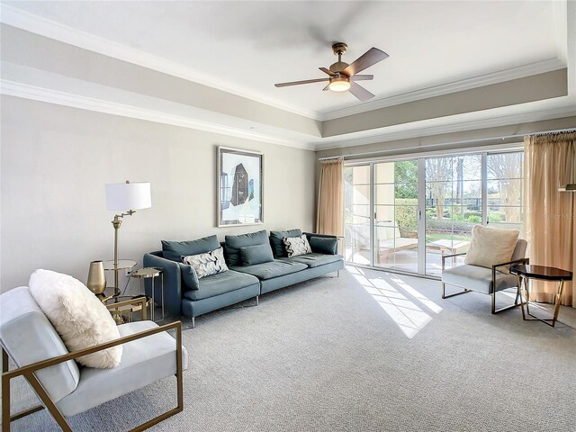 living room with ceiling fan, light colored carpet, and crown molding