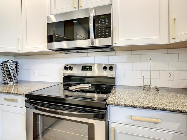 kitchen featuring appliances with stainless steel finishes, white cabinets, and tasteful backsplash