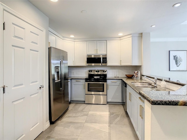 kitchen featuring dark stone countertops, appliances with stainless steel finishes, sink, kitchen peninsula, and decorative backsplash