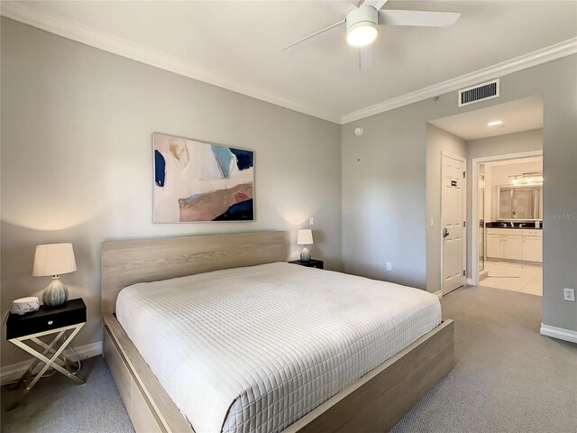 carpeted bedroom with crown molding, connected bathroom, and ceiling fan