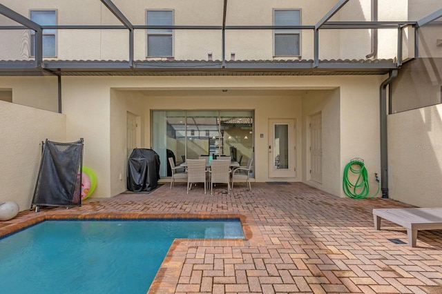 view of swimming pool featuring a grill, a lanai, and a patio