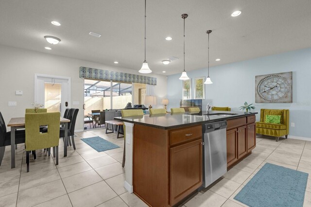 kitchen featuring pendant lighting, dishwasher, plenty of natural light, and a center island with sink