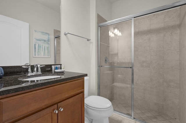 bathroom with a shower with door, vanity, and toilet