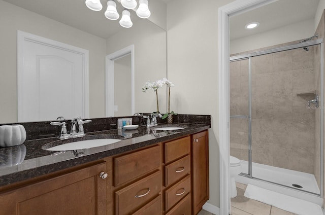 bathroom with vanity, toilet, tile patterned floors, and walk in shower