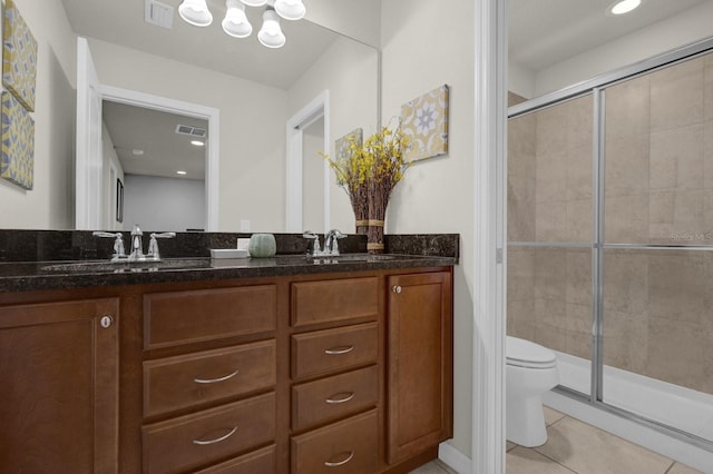 bathroom featuring vanity, toilet, an enclosed shower, and tile patterned flooring