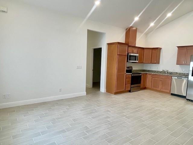 kitchen featuring light wood-type flooring, sink, and appliances with stainless steel finishes