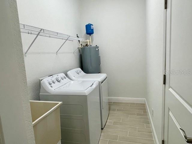 laundry room with light hardwood / wood-style flooring, washer and clothes dryer, sink, and electric water heater