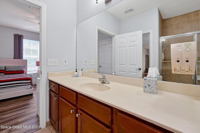 bathroom featuring vanity, wood-type flooring, ceiling fan, and a shower with door