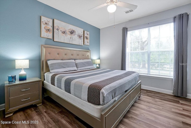 bedroom with dark wood-type flooring, ceiling fan, and multiple windows