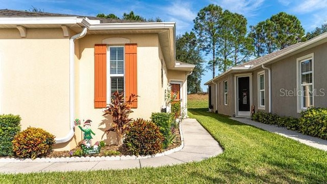 view of home's exterior with a lawn and stucco siding