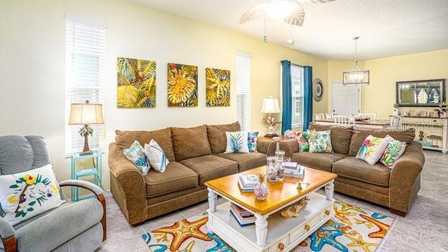 living area with a textured ceiling and a ceiling fan