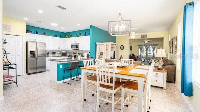 kitchen featuring stainless steel appliances, visible vents, an inviting chandelier, white cabinets, and a kitchen island