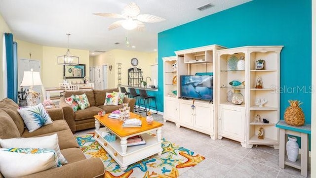 tiled living room with ceiling fan and visible vents