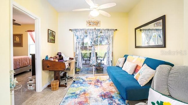 tiled living area with a ceiling fan and baseboards