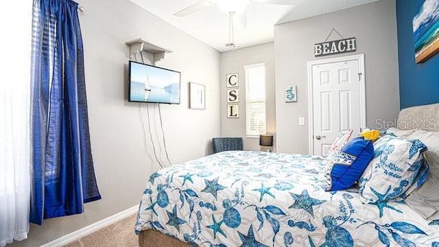 carpeted bedroom with a ceiling fan and baseboards