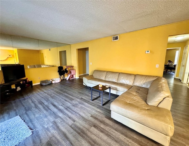 living room with dark hardwood / wood-style flooring and a textured ceiling