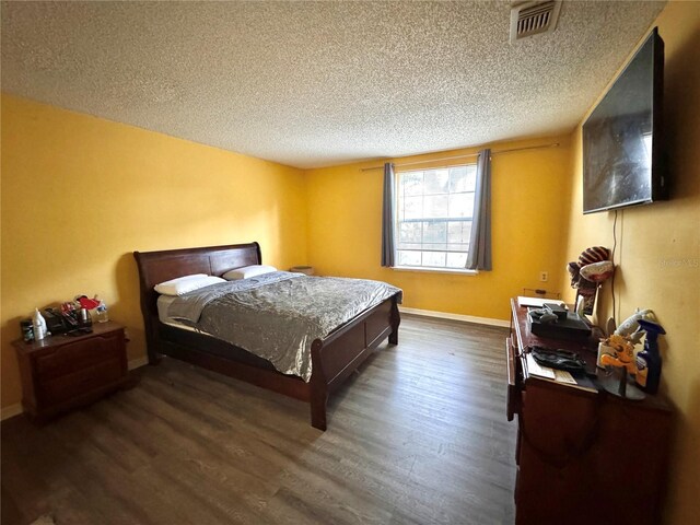 bedroom with dark wood-type flooring and a textured ceiling