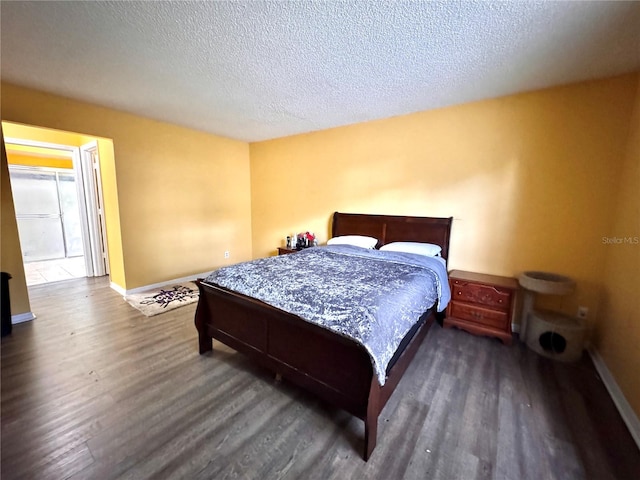 bedroom featuring a textured ceiling and dark hardwood / wood-style floors