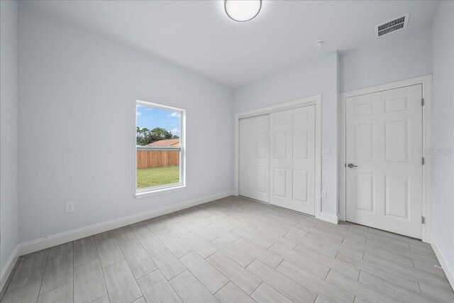 unfurnished bedroom with light wood-type flooring and a closet