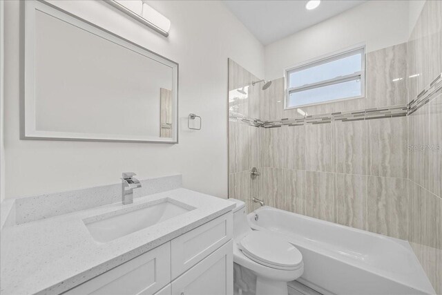 full bathroom with vanity, toilet, and tiled shower / bath