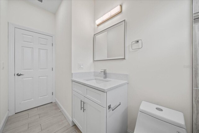 bathroom featuring hardwood / wood-style floors, toilet, and vanity