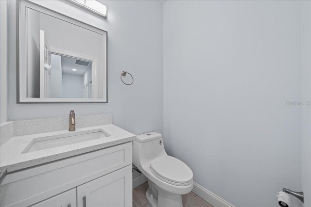 bathroom featuring vanity, toilet, and hardwood / wood-style floors