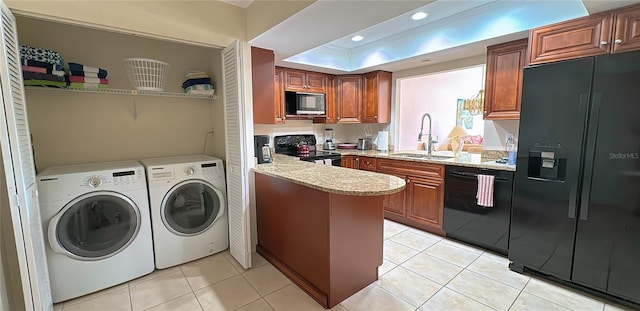 laundry area with light tile patterned floors, washer and dryer, and sink