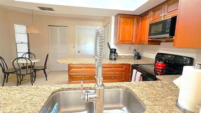 kitchen featuring black / electric stove, kitchen peninsula, decorative light fixtures, and light tile patterned flooring